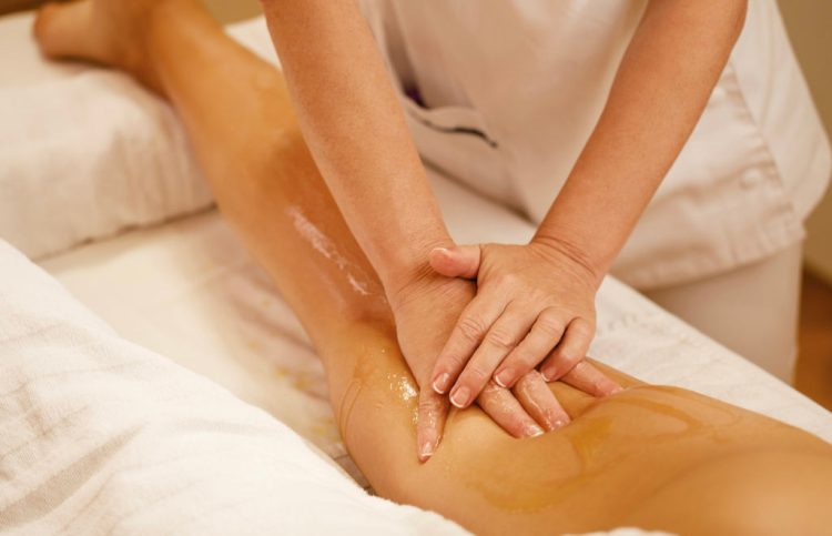 femme sur une table de massage se faisant drainer les jambes